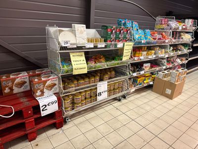de nombreux rayons de produits alimentaires dans le magasin, avec les prix indiqués dessus
