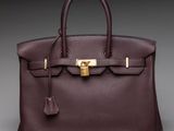 a brown leather handbag with a gold lock on the handle