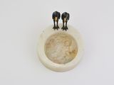 two small figurines that are on top of a bowl