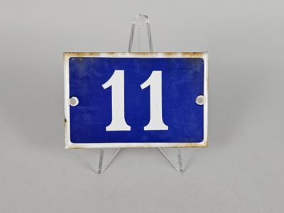 une photo d'une plaque de numéro de maison bleue et blanche fixée sur un support métallique