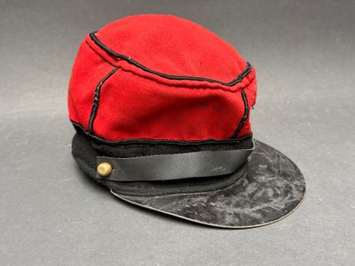 un chapeau rouge orné d'un ruban noir
