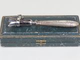 an antique silver plated knife sitting on top of a green box
