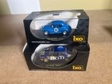 Deux petites voitures se trouvent dans une boîte posée sur une table