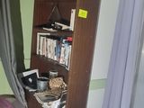 a bookshelf in the corner of a room with a purple bed