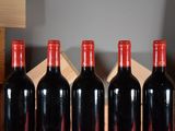 four bottles of red wine sit in a row on a table