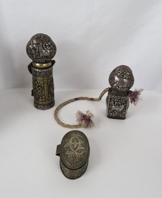 trois pièces d'argenterie ancienne posées sur une surface blanche