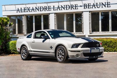 a white mustang parked in front of a building