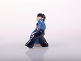 a small figurine of a man sitting on a bench