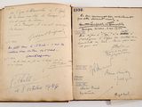 an open book with handwriting on it sitting on top of a table