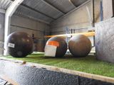 three balls that are sitting on the grass in the room