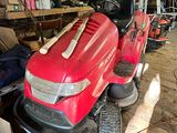 a red lawn mower parked in a garage