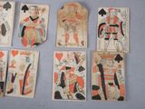 several playing cards of different colors and designs on a blue surface