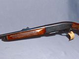 the rifle is laying on a white surface with a green hat