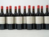 six bottles of red wine lined up in a row on a table