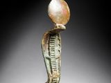 an egyptian bronze figurine of a man with a pearl on his head