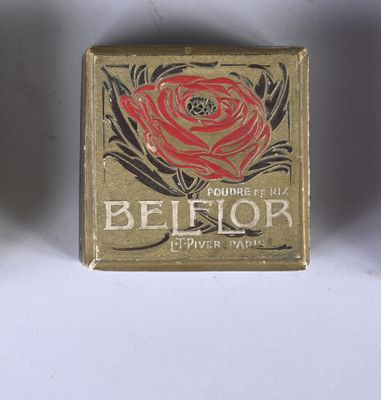 an old match box with a rose on it sitting on a table