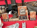 une petite horloge posée sur une table, à côté d'autres objets
