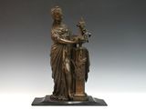 statue en bronze d'une femme tenant un oiseau sur un piédestal