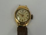 a gold wrist watch with a brown leather strap