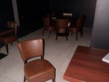 des tables et des chaises dans une pièce sombre, avec un livre posé sur une table