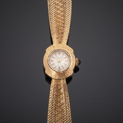 gros plan d'une montre-bracelet en or avec un cadran blanc