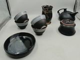 plusieurs assiettes et tasses noires et blanches posées sur une table blanche