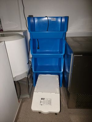 une poubelle bleue située à côté de toilettes blanches
