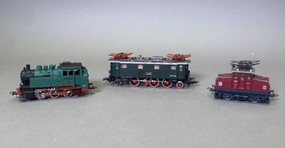 trois petits trains assis côte à côte sur une surface blanche