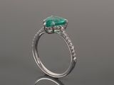 a close up of a ring with a green stone and diamonds