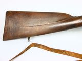 an old wooden rifle with a long wooden handle and a leather strap