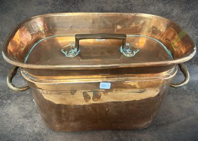 a large copper pot with a handle on it