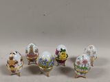 four miniature porcelain eggs with flowers and birds on them