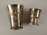 two silver cups sitting next to each other on a table