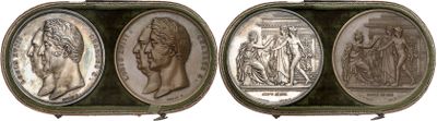 two silver medallions of a woman and a man in a green case