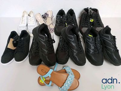 Plusieurs paires de chaussures sont alignées sur une surface blanche
