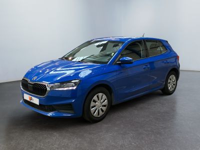 une voiture bleue garée dans une pièce aux murs blancs