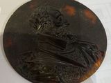 a picture of a bronze plaque of a man with a beard