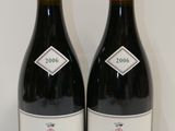 deux bouteilles de vin rouge posées l'une à côté de l'autre sur une table