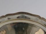 a silver plate with a silver handle on a table