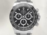 a close up of a watch with a black dial and a silver bracelet