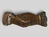 a wooden carving of a hand holding a brush