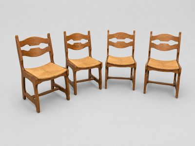 four wooden chairs are lined up in a row on a white surface