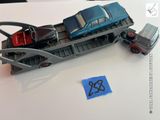 une petite voiture et un camion posés sur un train posé sur une table