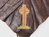 brown leather collar with a cross on it on a white surface