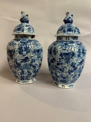 une paire de vases bleus et blancs ornés de paons