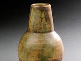 un vase marron et vert posé sur une table