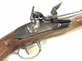 an old gun with a wooden handle on a white surface