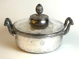 une cocotte en argent avec un couvercle posée sur une table