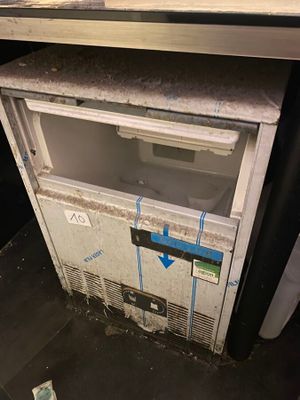 un petit réfrigérateur qui se trouve dans un coin de la pièce