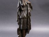 a bronze statue of a woman holding a dog on a wooden base